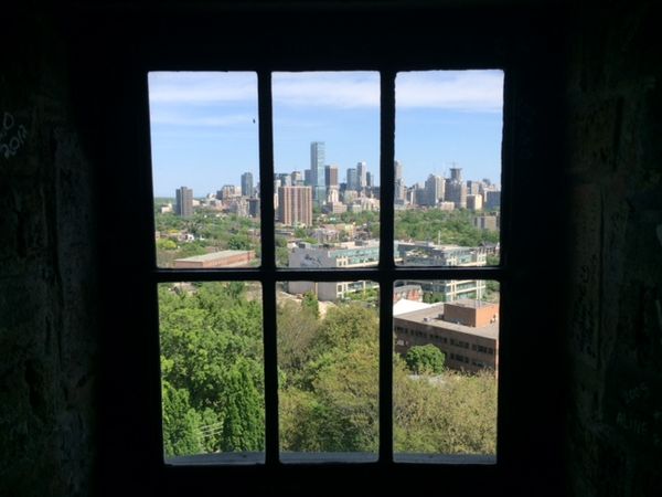 view of a city's skyline thorough a window with bars