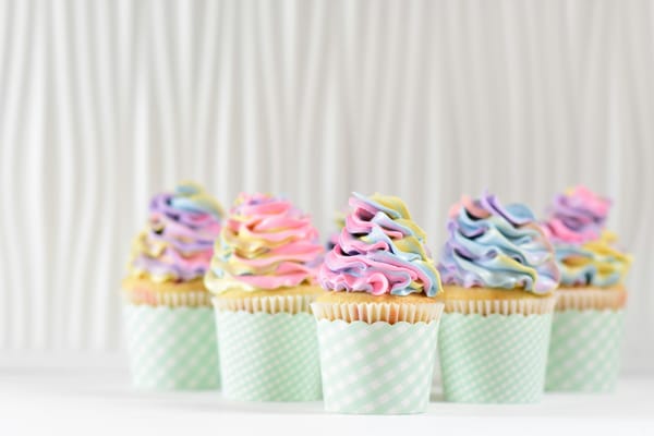 five cupcakes with multi-coloured icing