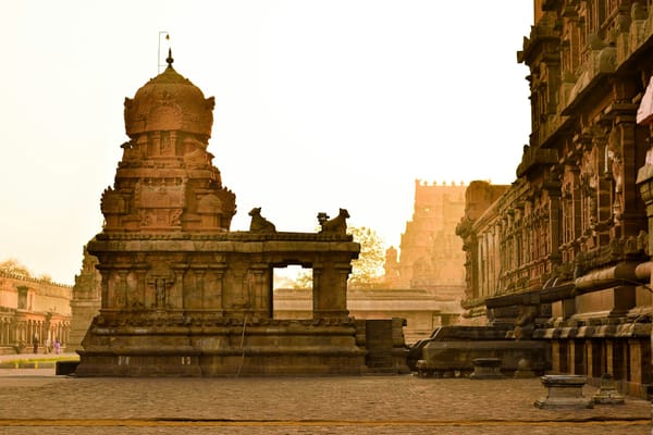 an ornate South Indian temple with intricate structures glowing in the light of the morning sun